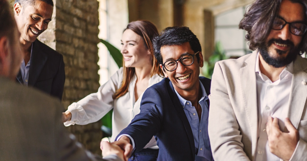 Multicultural business professionals greeting one another at a business networking event